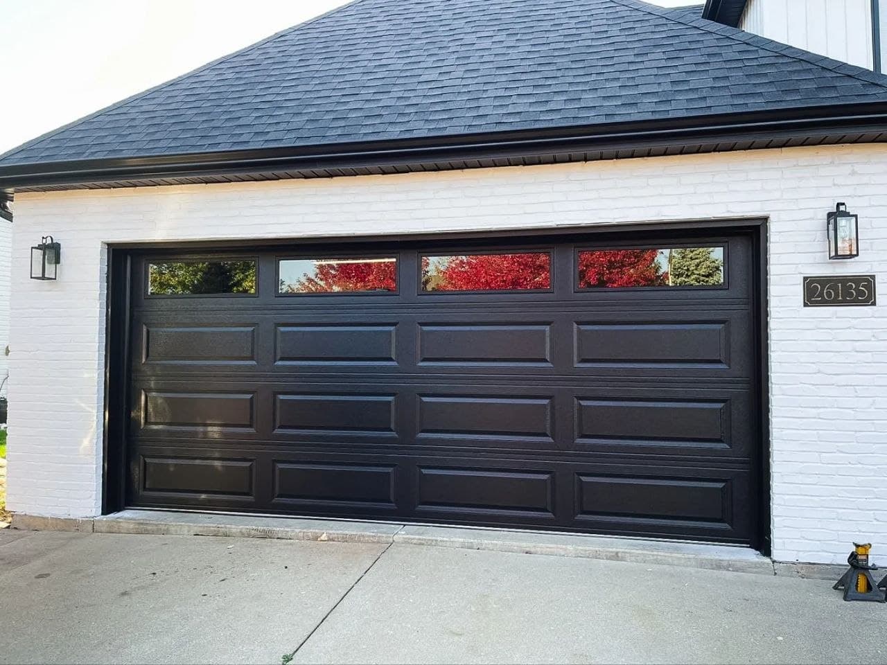 Modern black garage door installed on white brick home in Atlanta